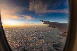 Reiseflughöhe - Blick aus Kabinenfenster Blick aus dem Flugzeugfenster auf eine lockere Wolkenschicht - Flugangst überwinden - Karen Hartig Coaching in Köln und NRW