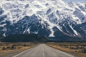 Straße in Richtung eines schneebedeckten hohen Berges - Was Coaching kann - Karen Hartig Coaching Köln und NRW