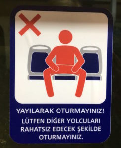 Schild in der Metro von Istanbul gegen Manspreading. Es fordert dazu auf, nur einen Platz zu belegen.